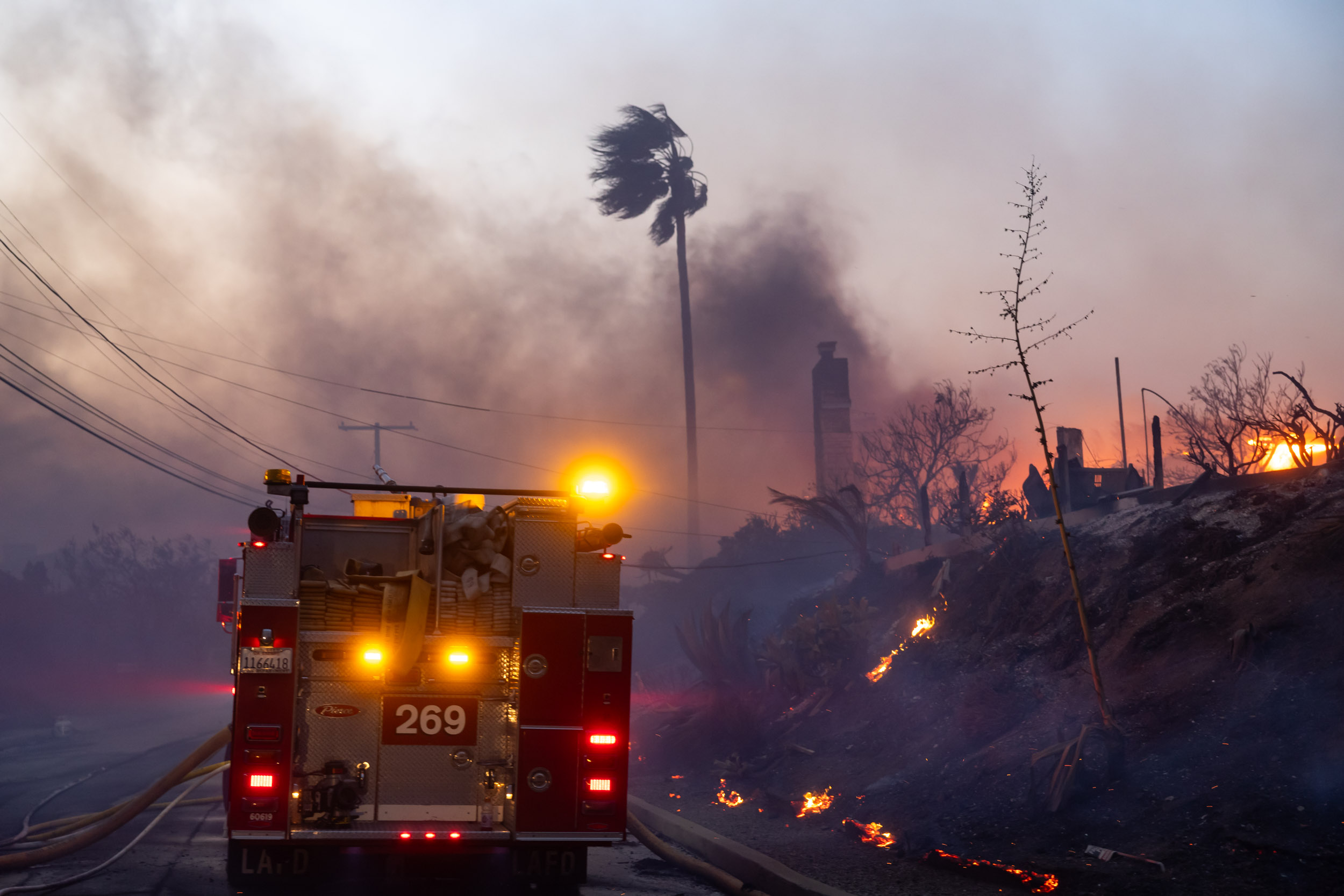 LAFD firefighting crews work on El Medio Ave in Pacific Palisades during the evening hours on January 7, 2025. (Brian Feinzimer / L.A. TACO.)