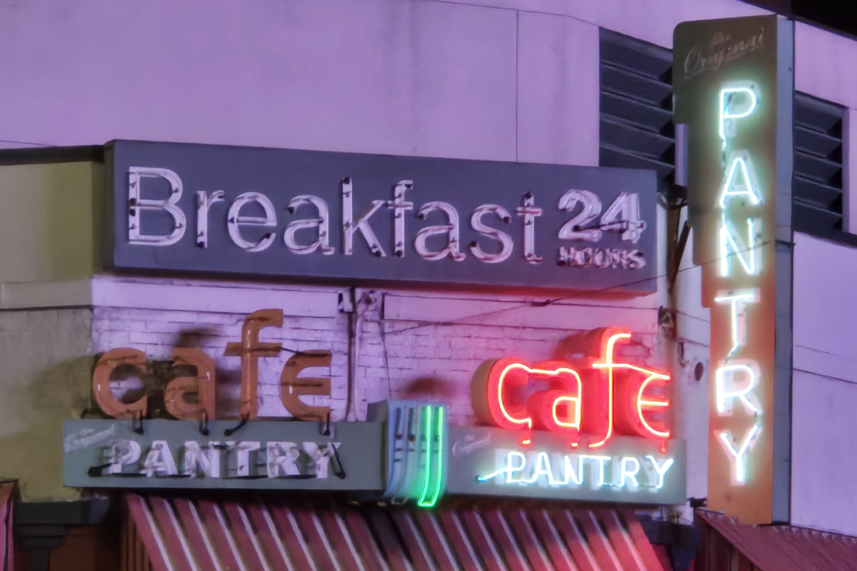 The Original Pantry Cafe's neon lights lit up at night.