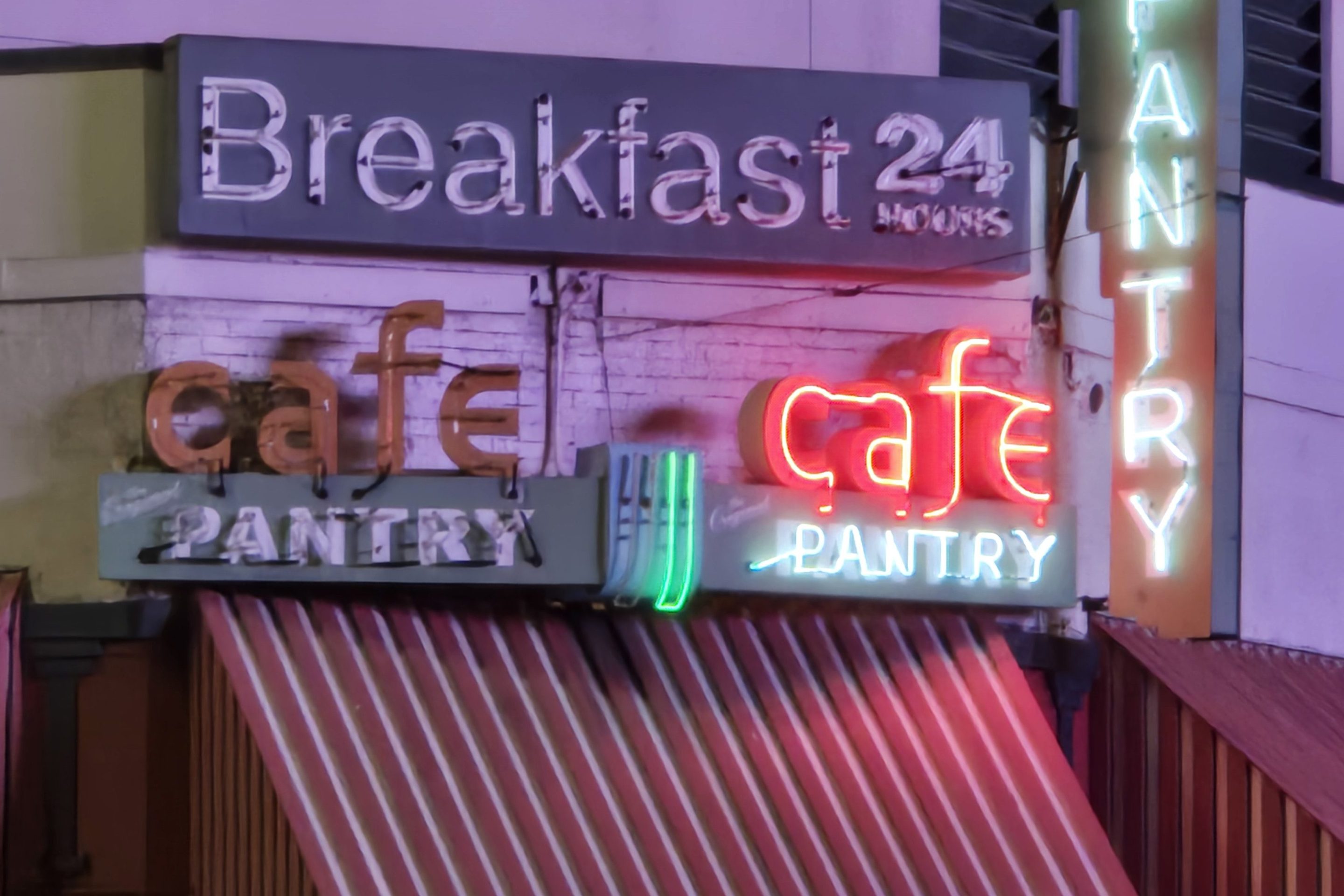 The Original Pantry Cafe's neon lights lit up at night.