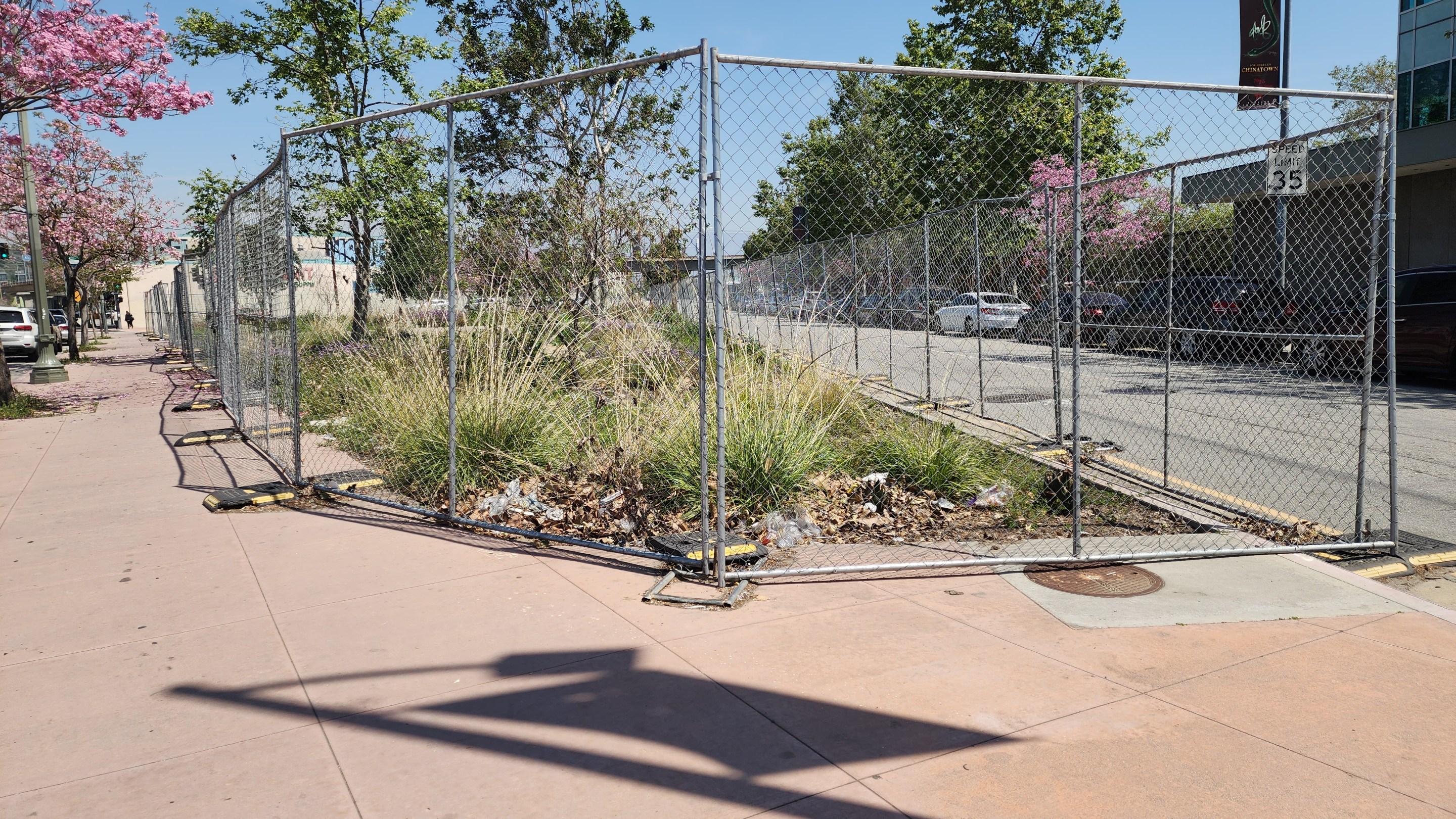 A chain link fence surrounds Alameda Triangle in Chinatown.