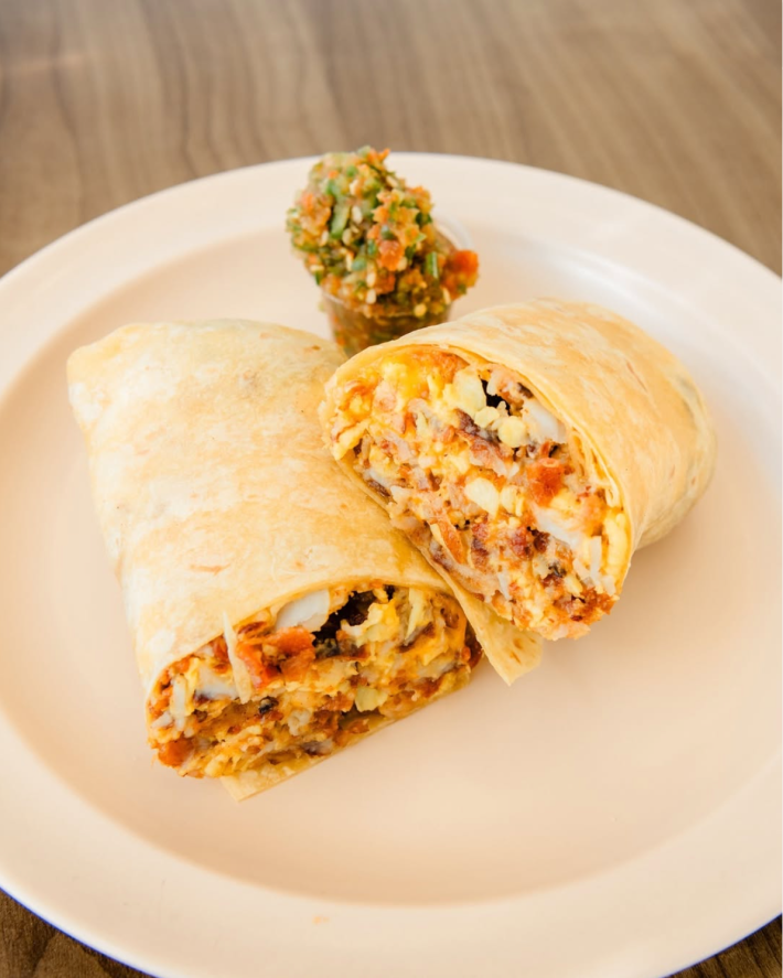 Their breakfast burrito is the perfectly cooked mixture of potato, and eggs, and your choice of bacon, sausage, or ham. Topped with their chunky salsa.