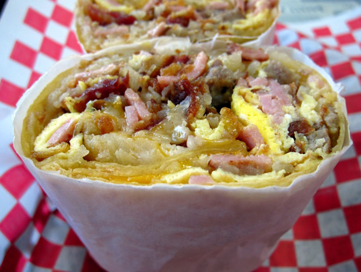 Breakfast burrito with bacon, ham, sausage eggs and hash.