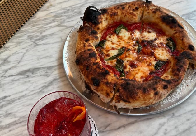 A pizza with a puffy cornicione and a negroni. Photo via Pizza Ananda/Instagram.