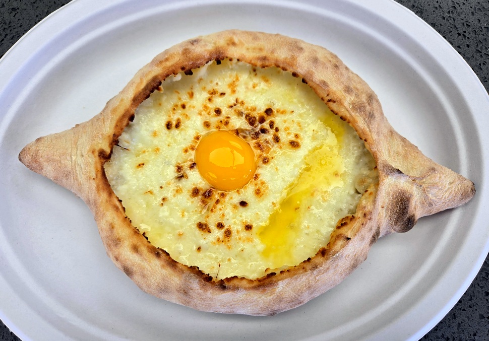 Adjaruly freshly baked bread with raw egg and cheese.