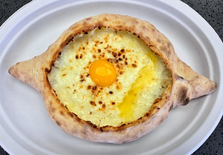Adjaruli khachapuri at Saqartvelo, an eye-shaped bread filled with cheese, butter, and a raw egg yolk.