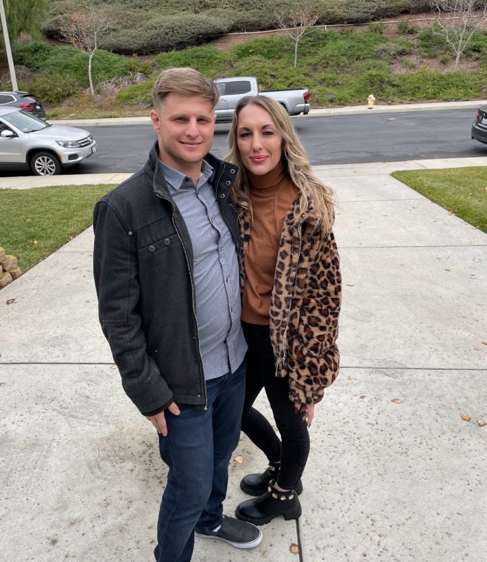 Jason Maccani and Alex Smith pose for a photo in a driveway.