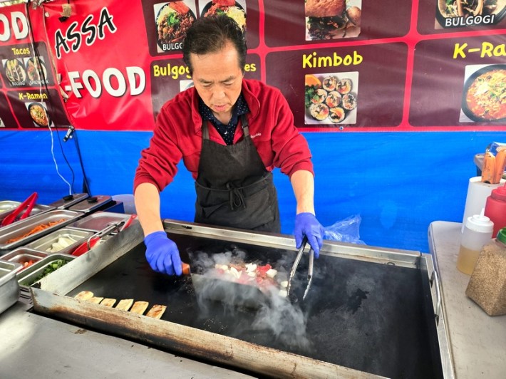 Chef Ken Lee, with his bulgogi and a lineup of mandu grilling on a flattop grill at Assa.