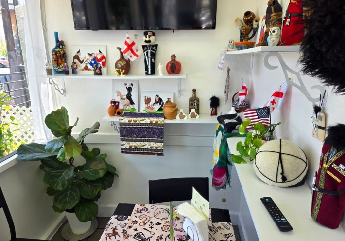 A nook festooned with traditional Georgian knickknacks over a dining table.