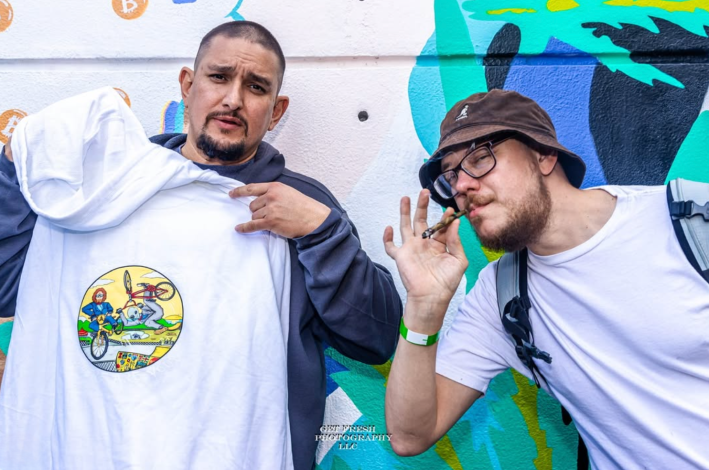 People posing for a photo with a hoodie and a joint.