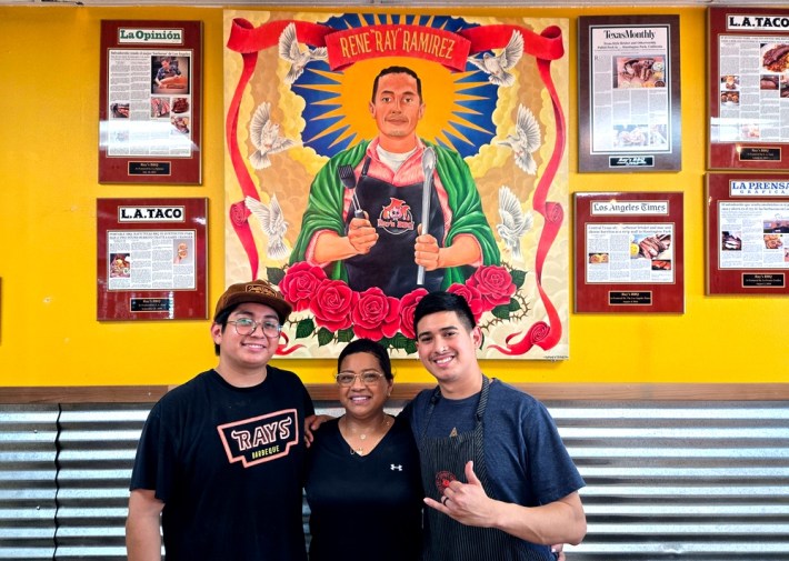 Raul, Annabel, and Sebastian Ramirez of Ray's BBQ, in front of a mural honoring the family patriarch Rene "Ray" Ramirez.