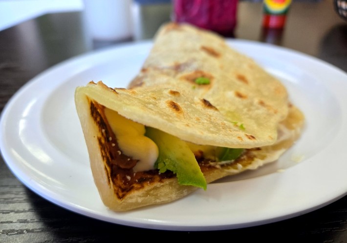 A baleada with crema, avocado, chorizo, beans, and egg on a housemade flour tortilla. Photo by Hadley Tomicki.