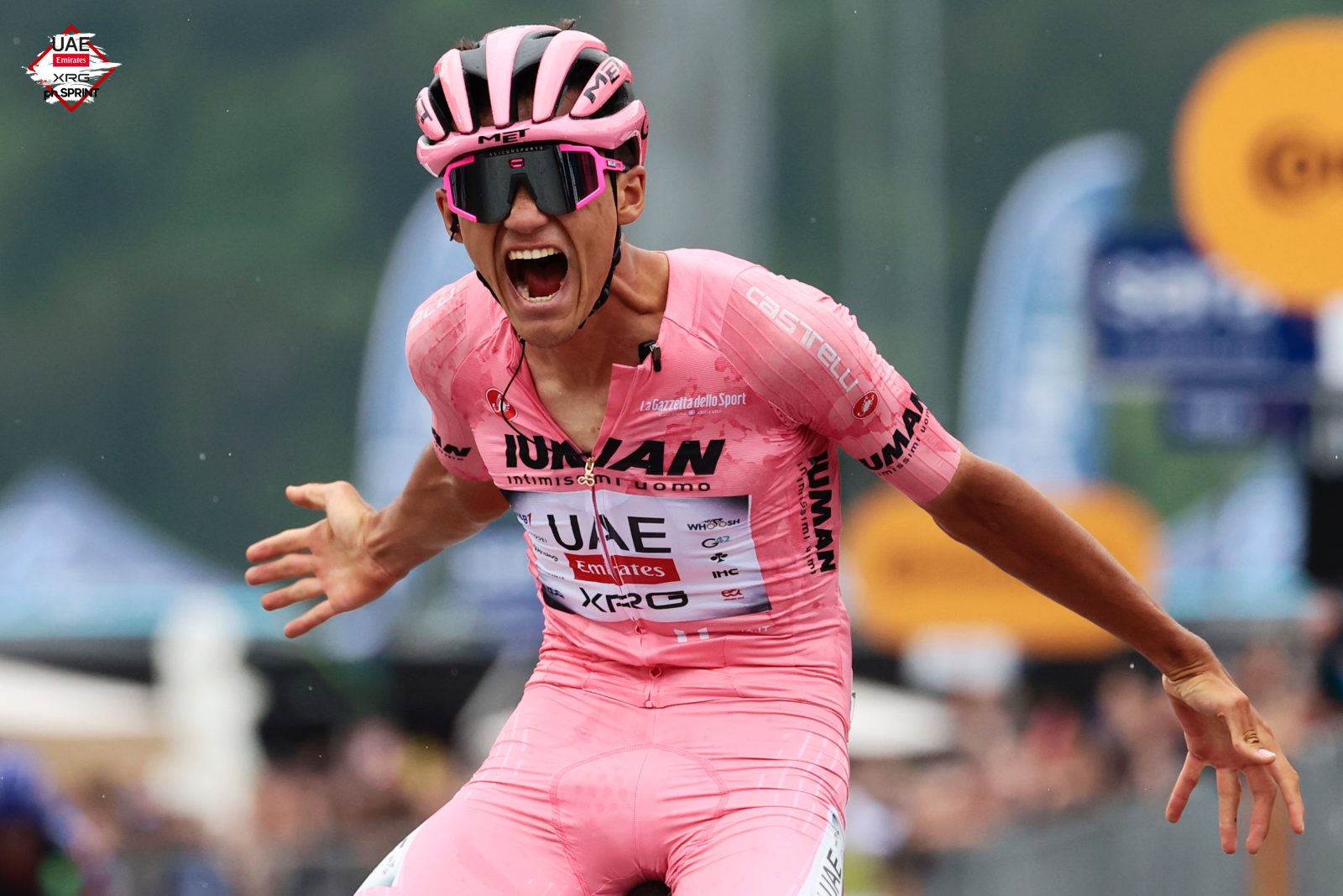 Wearing the pink jersey, Isaac del Toro celebrates after winning his first Grand Tour stage victory.