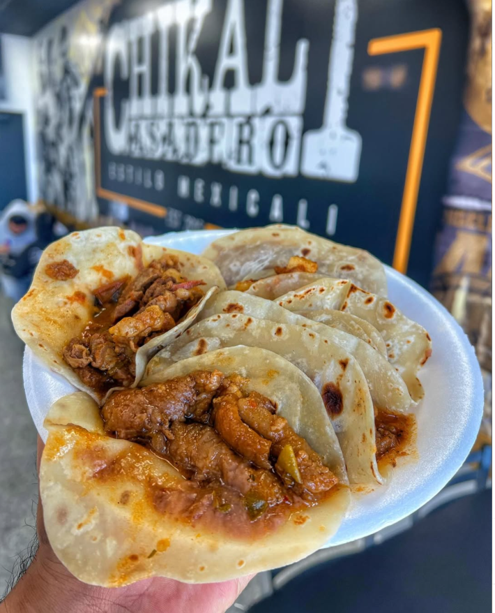 Tacos de guisados in a white plate.