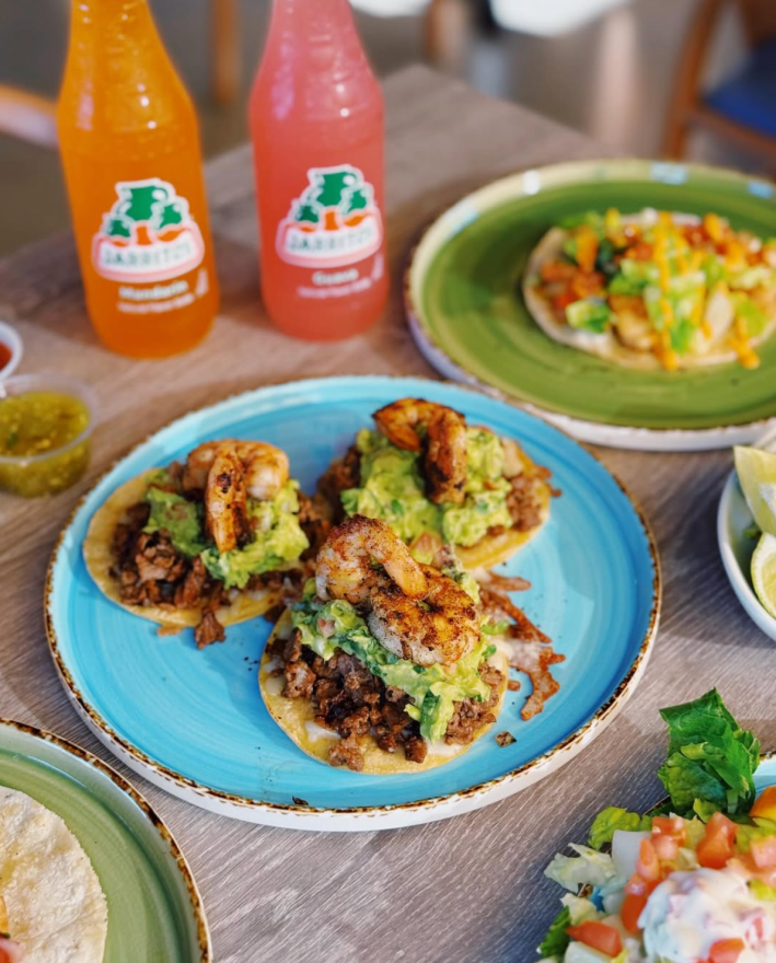 Surf and turf taco on a blue plate.