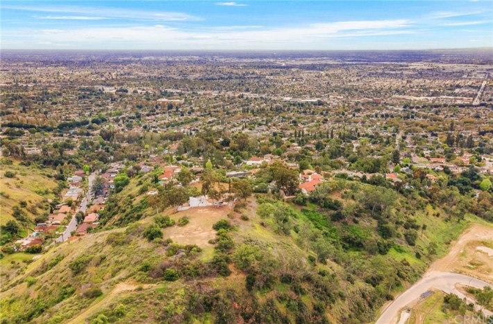 A beautiful shot of Whittier Hills and the suburban neighborhood below, with lots of green hills and trees and adobe-roofed houses