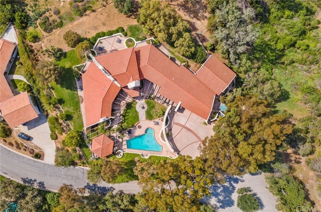 A huge mansion with a pool and adobe tile roof in the neo-Spanish design style