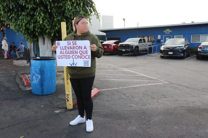 Union del Barrio member stands outside the swap meet providing resources for those impacted.