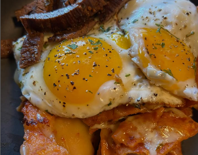 Chilaquiles Rojos with carne asada and eggs. Photo via Kitchen Gangstas.