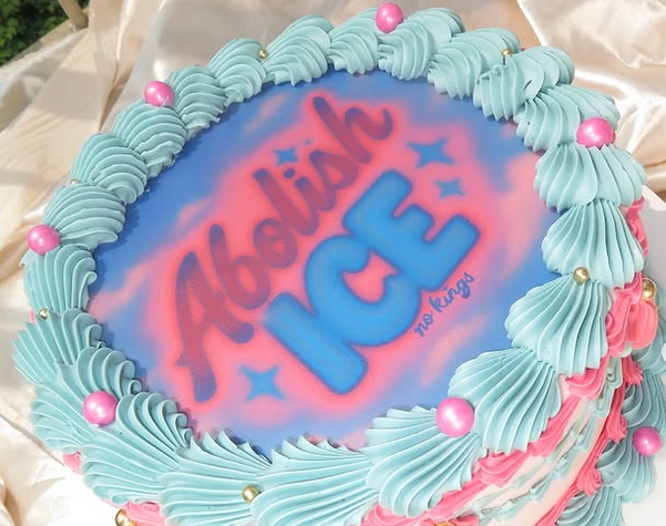A pink and blue cake that says Abolish ICE