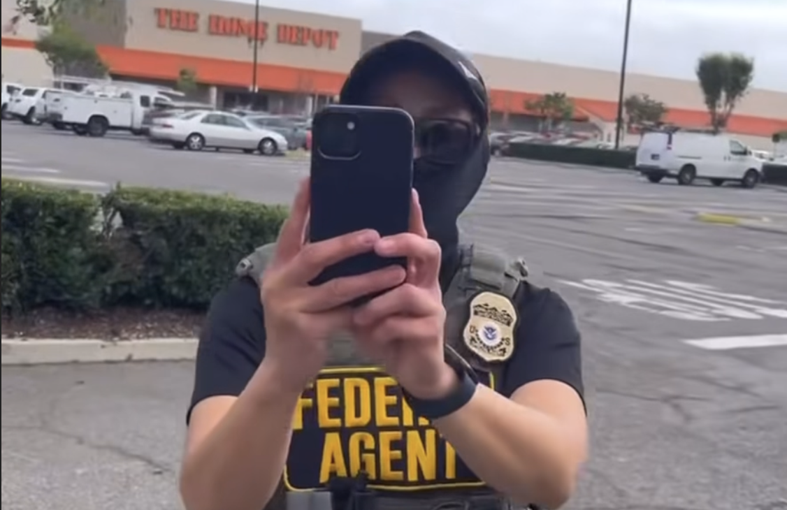 A "Federal Agent" holds their phone up to record a person recording them at the home depot parking lot in Playa Del Rey.