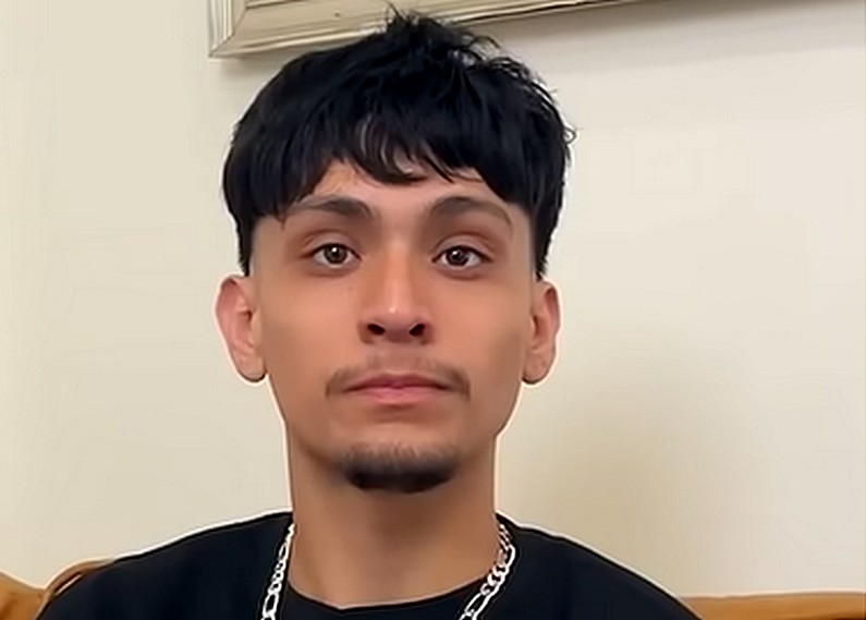 A young man with a goatee looks with big eyes at the camera
