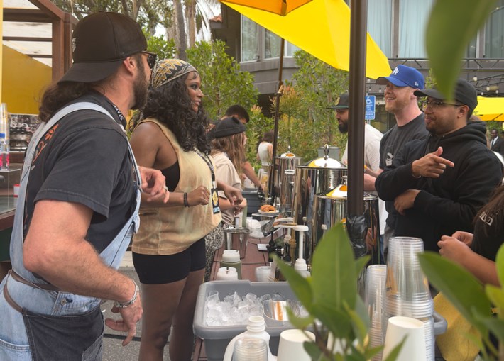 Two people talk with baristas at a morning rave party