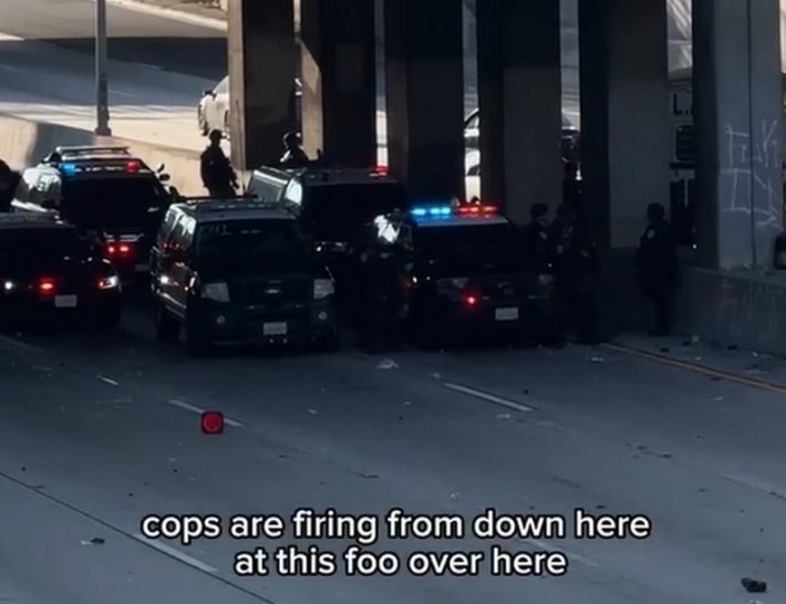 A gathering of police cars and officers under a bridge on the 101 freeway
