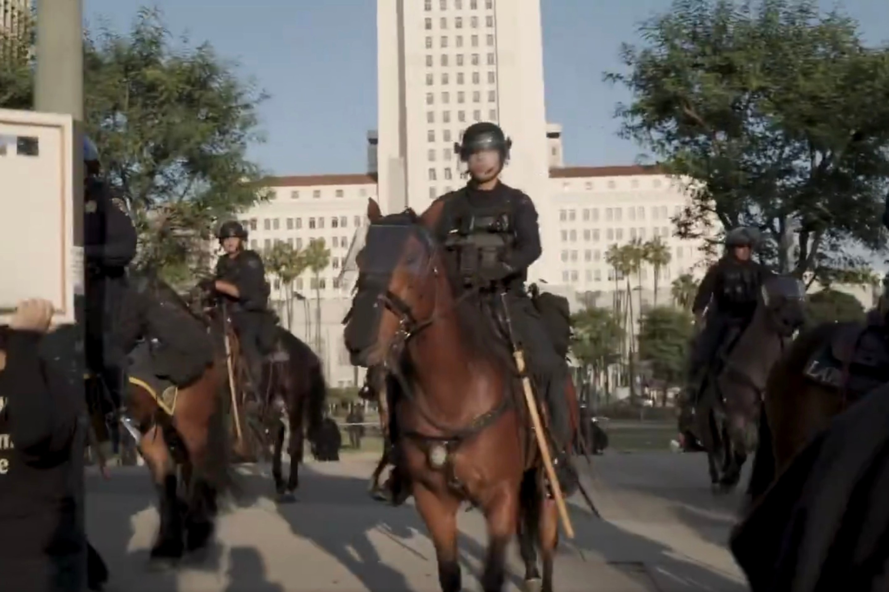 A police officer on a brown horse in front of LA's City Hall
