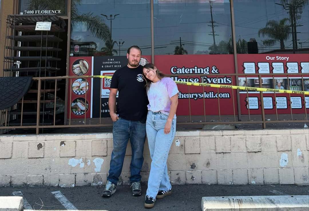 The two owners of Uncle Henry's Deli, a man and a woman, with their arms around each other, facing forward