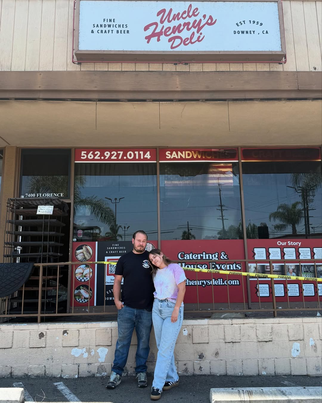 The two owners of Uncle Henry's Deli, a man and a woman, with their arms around each other, facing forward