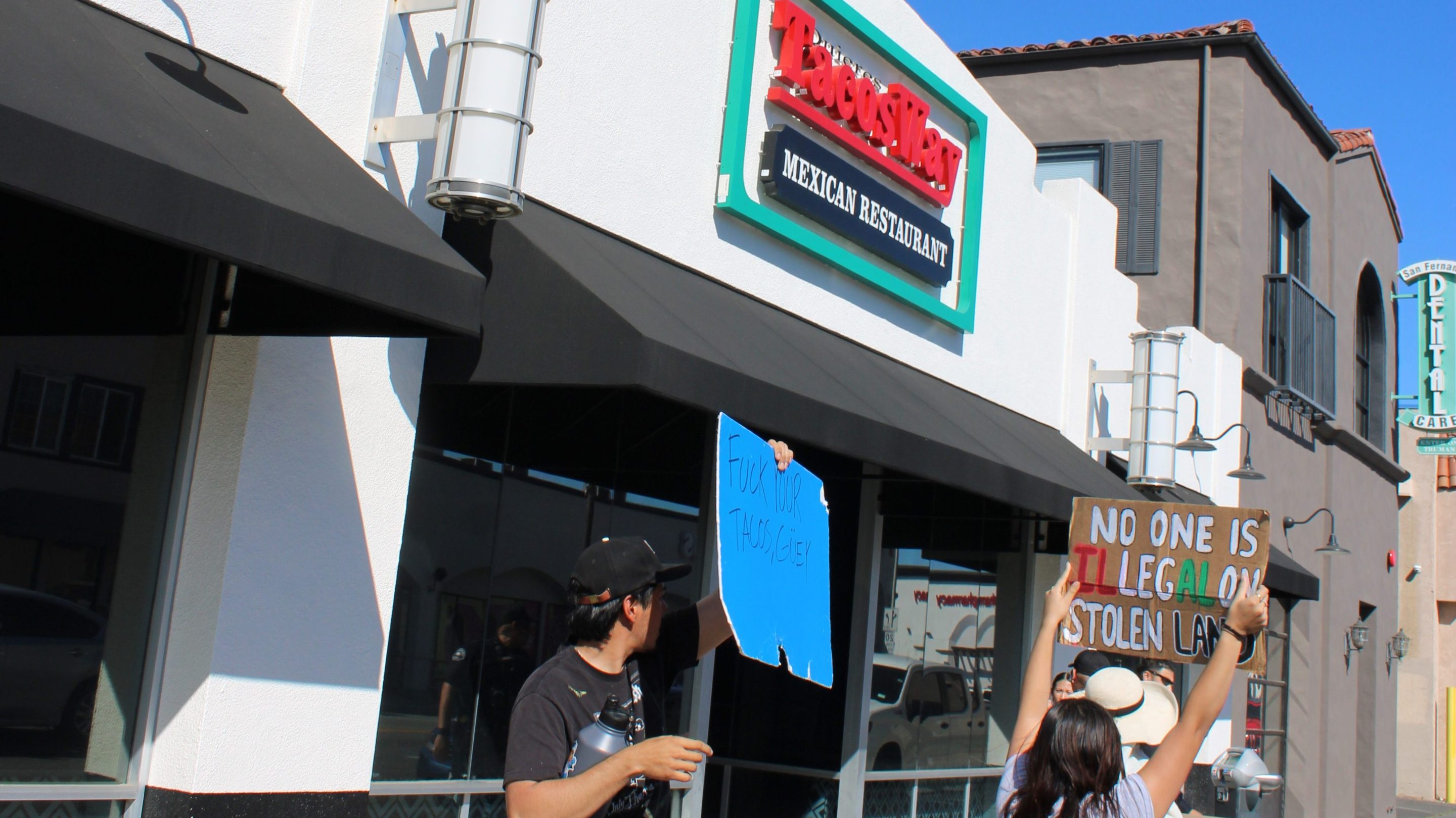 A protester holds a sign saying "fuck your tacos, guey." Photo courtesy of Valley Views SFV Media.