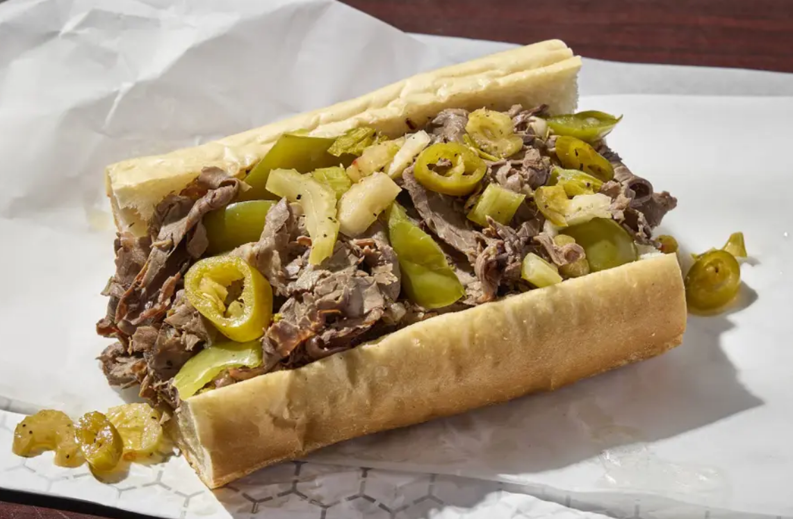 Italian beef sandwich with peppers, between a roll of white bread