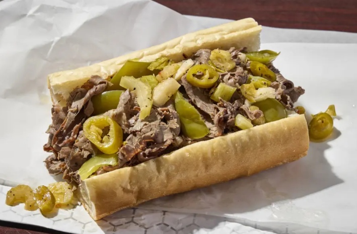 Italian beef sandwich with peppers, between a roll of white bread