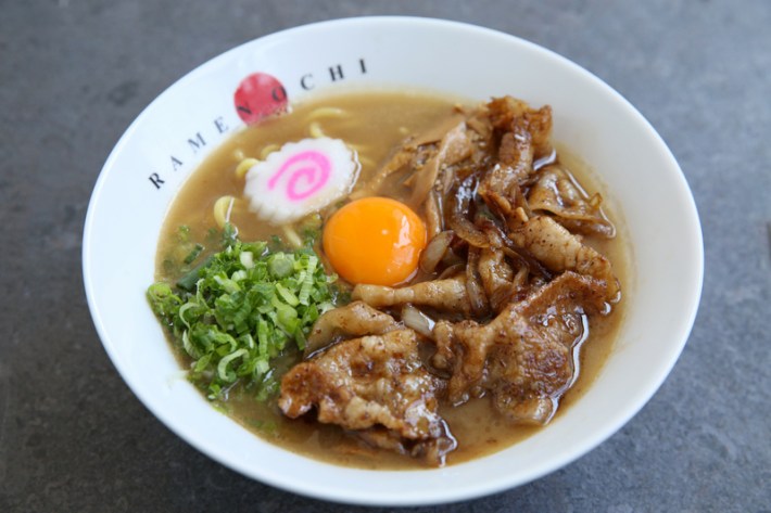 a bowl of nikutama Ramen at Ramen Ochi with a raw egg, pinkswirled daikon, and shreds of meat and green onions