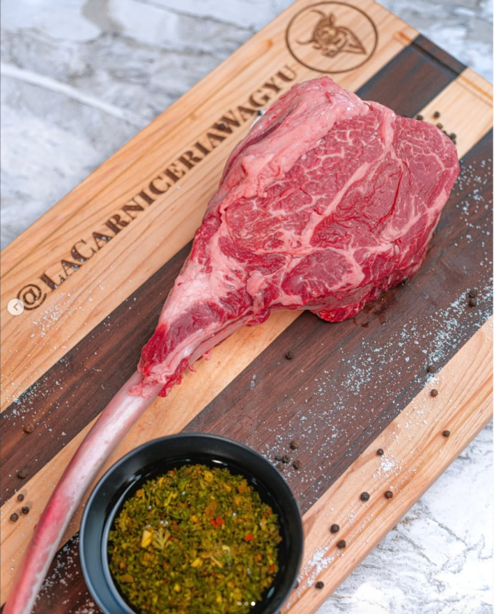 raw meat on a wood board with seasoned oil on the side.