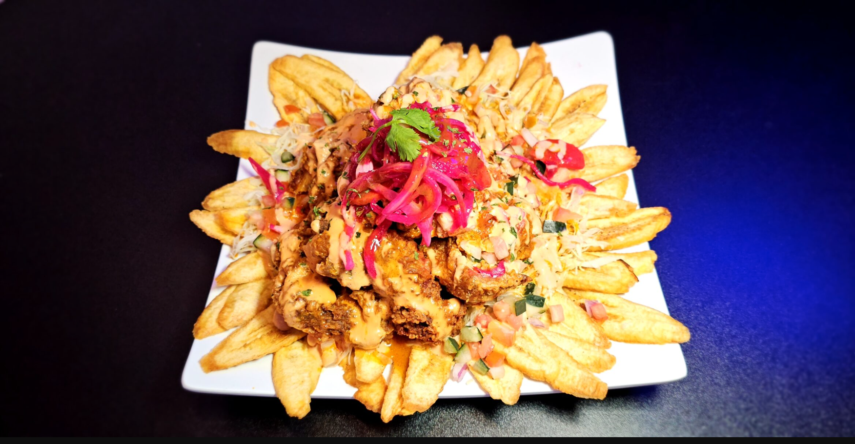 Fried chicken with plantains, toppings and a special sauce.