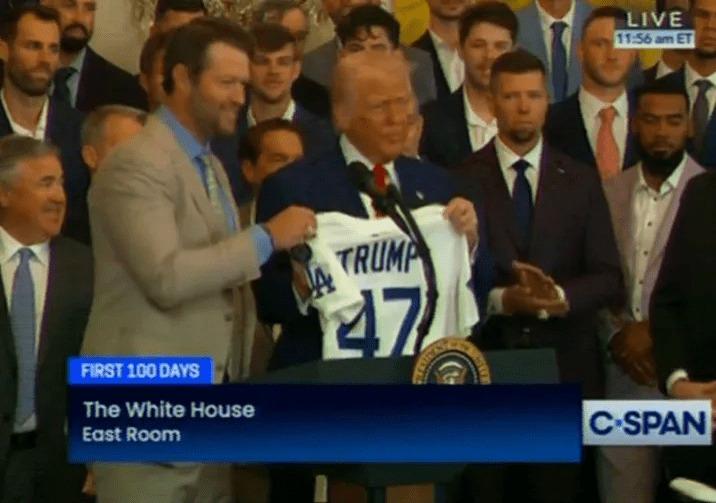 Clayton Kershaw of the Dodgers holds up a Dodgers jersey with Donald Trump