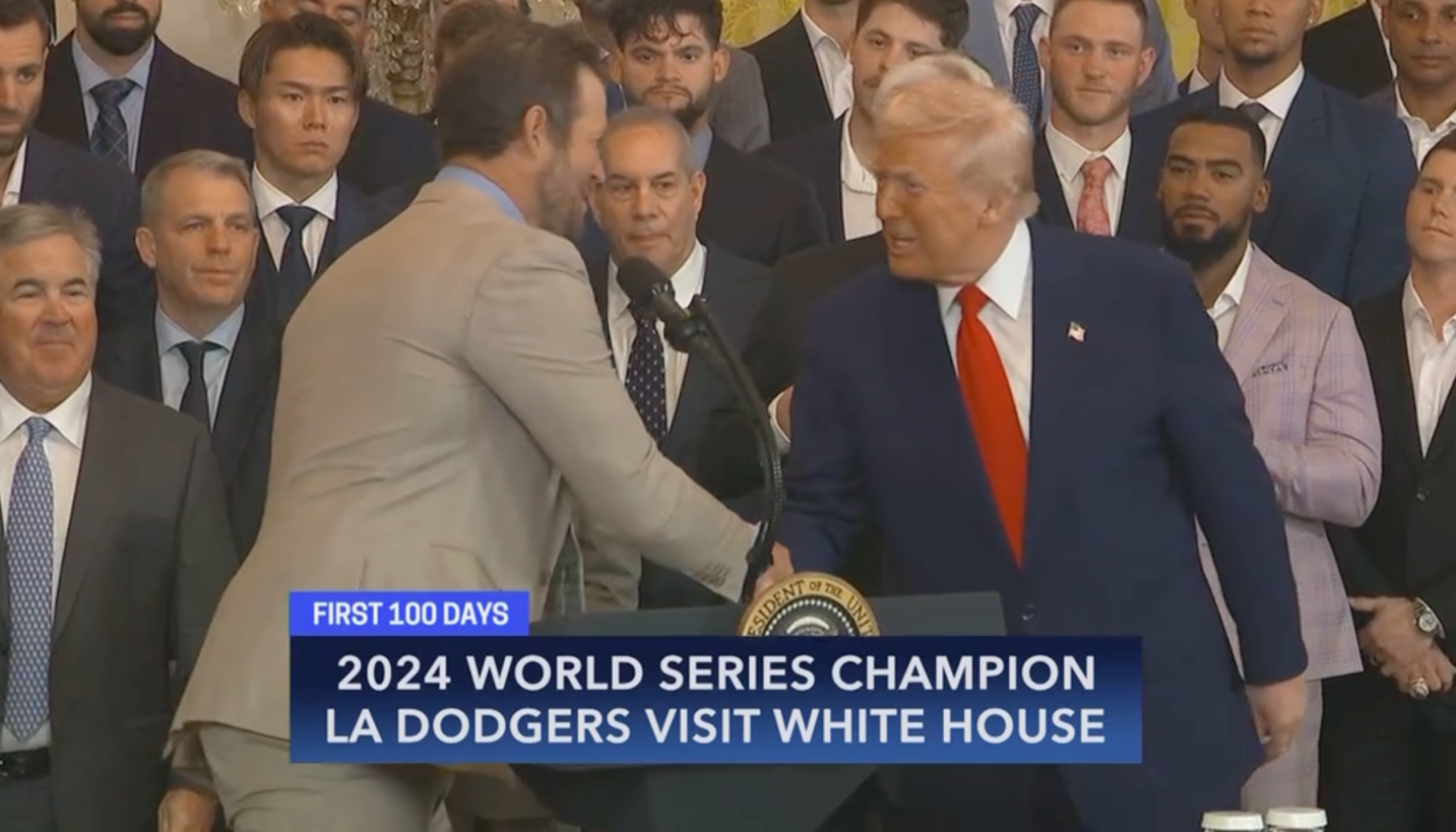 Clayton Kershaw of the Dodgers holds up a Dodgers jersey with Donald Trump