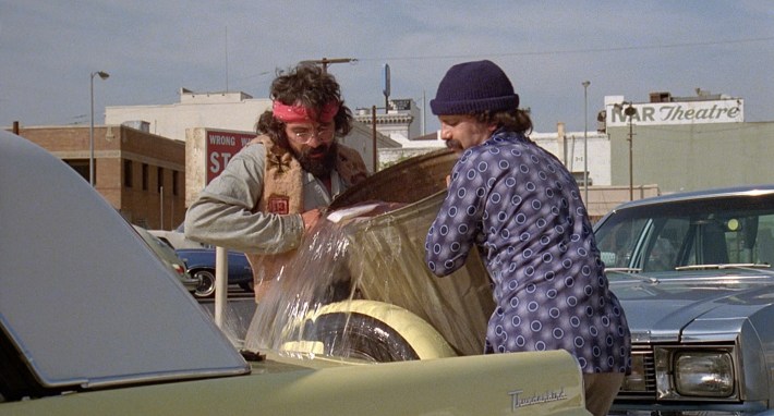 Cheech and Chong pouring gas into the Thunderbird. Screenshot via Universal Pictures.