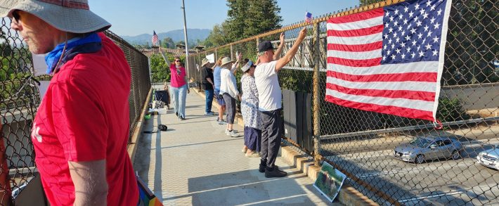 The San Fernando Valley Brigade waving at people commuting on the 101 freeway.
