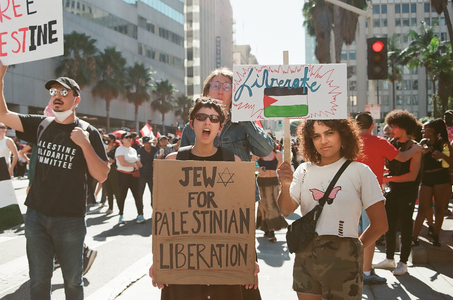 Photo of a Jewish person holding up a sign that says "Jews for Palestinian Liberation."