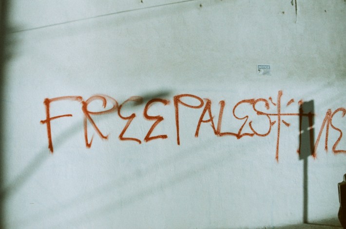 "Free Palestine" in L.A. Style cholo letters written on a white wall.
