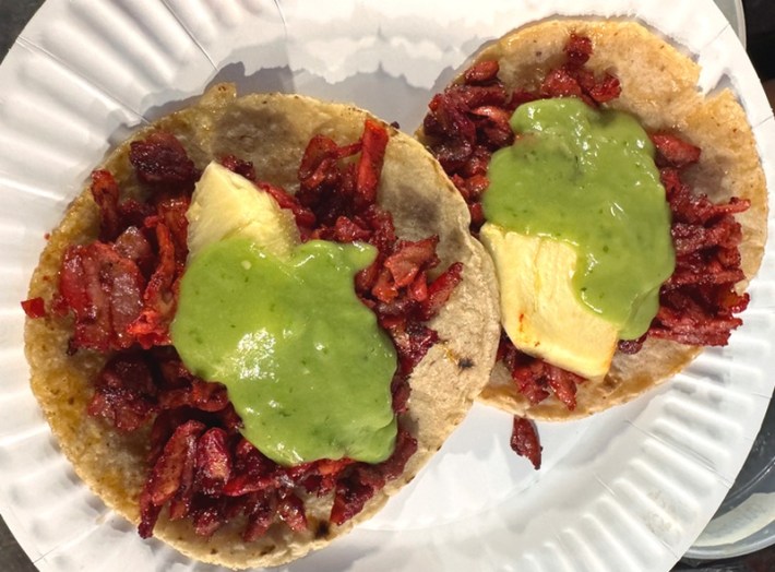 Two pineapple and guacamole-topped tacos depastor in Atladena