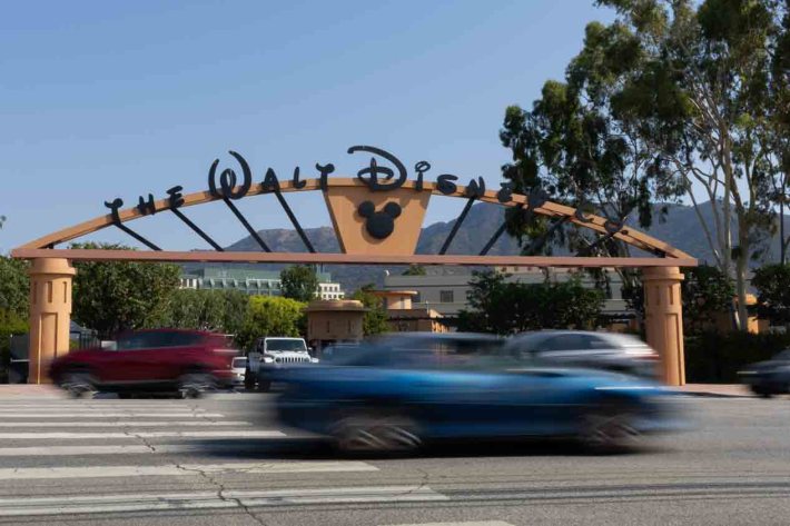 A view of the Walt Disney Studio gate,, with blurry cars racing by