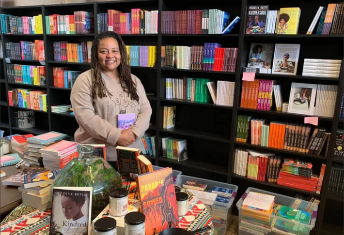 Nikki High, owner of Octavia's Bookshelf, standing among some of the books in her store