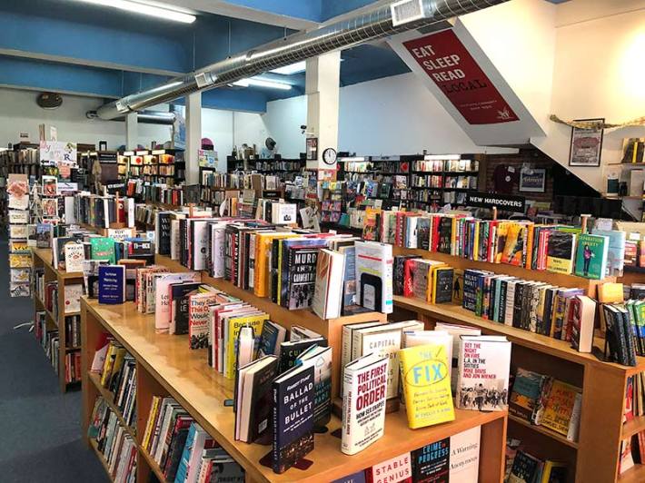 A bookstore full of bookshelves and hardcover books on top of the displays