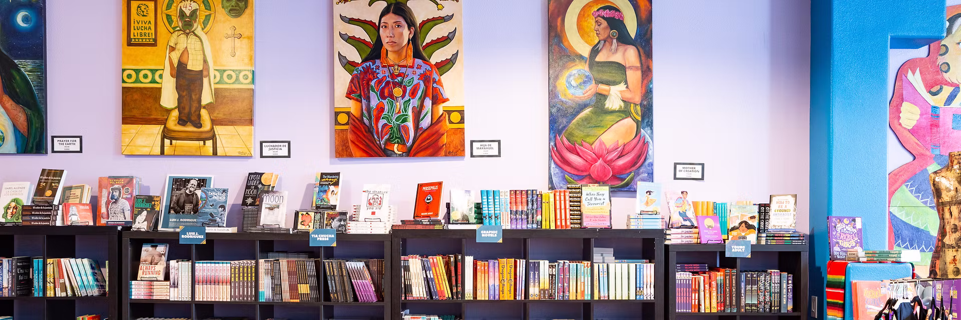 3 Mexican paintings hung over bookstore shelves and displays
