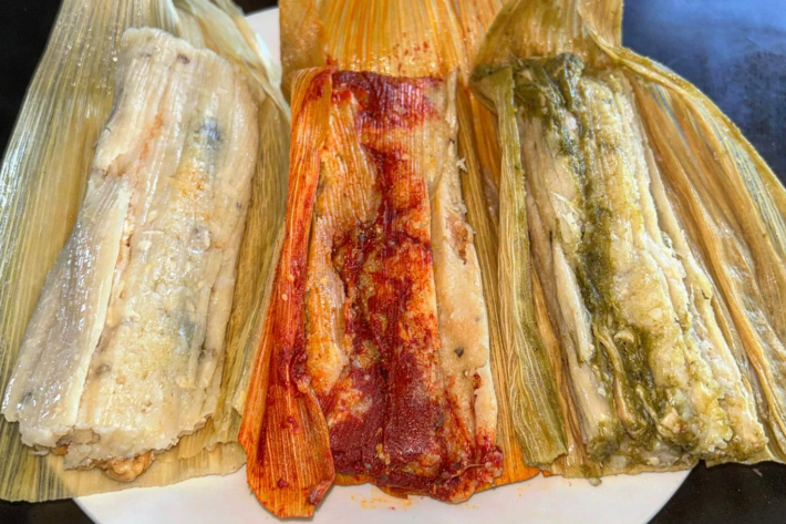 Three tamales are on a plate. Left to right: rajas, rojo, verde.