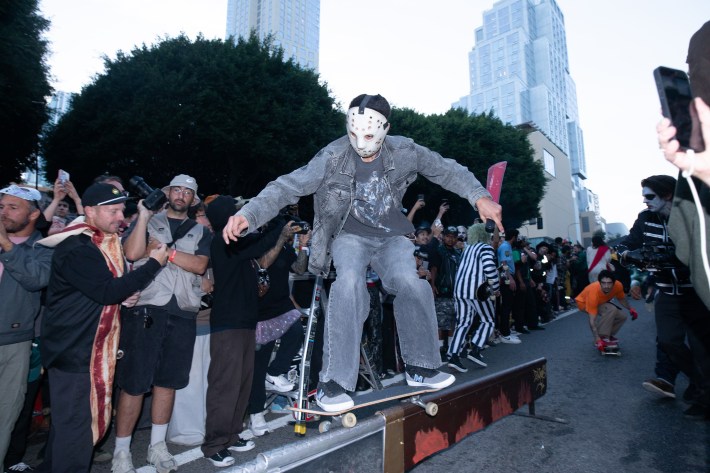 someone in a Jason-style hockey mask does a skateboard trick