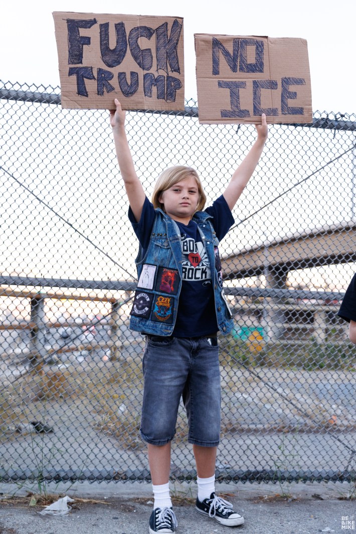 Kid holding up FUCK TRUMP and NO ICE.